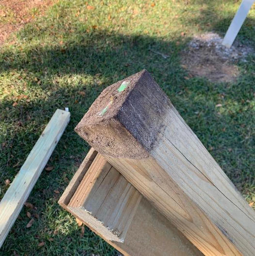 Photo of a wood fence post after being removed