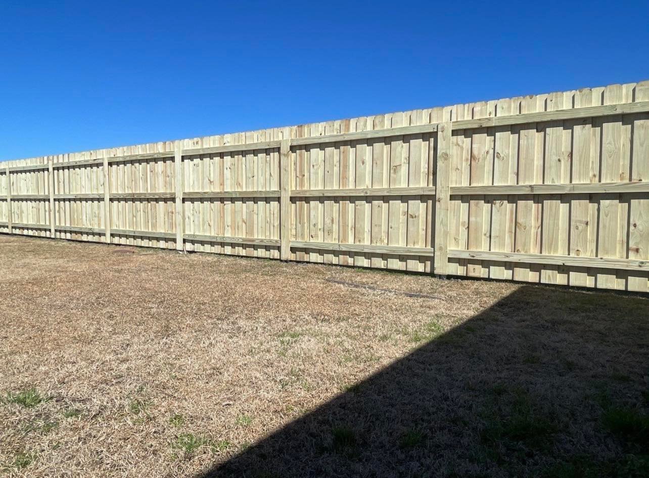 Photo of newly installed wood privacy fence with postmaster posts